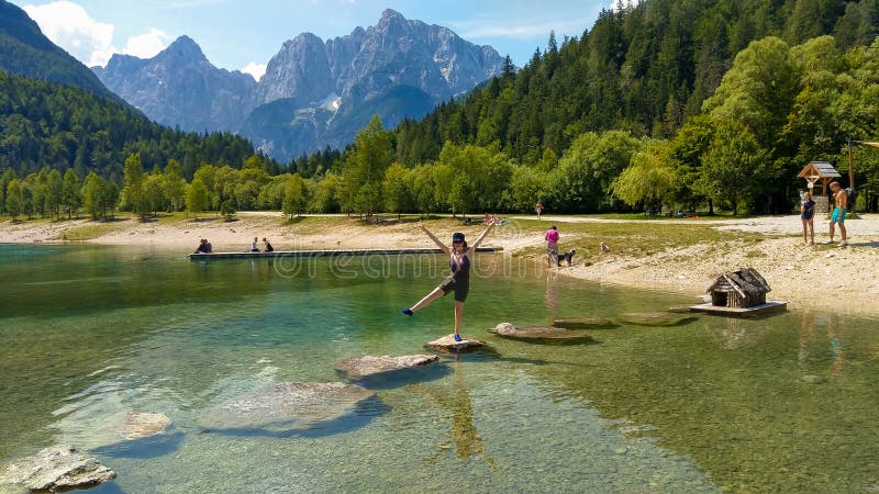 Szczęśliwa dziewczyna cieszy się wakacje na Jasna wysokogórskim jeziorze w Slovenia fotografia stock Szczęśliwa dziewczyna cieszy się wakacje na Jasna wysokogórskim jeziorze w Slovenia fotografia stock