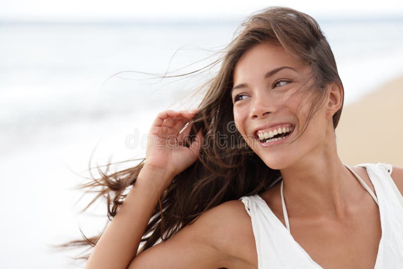 Szczęśliwa dziewczyna na plaży - szczera młoda kobieta radosna