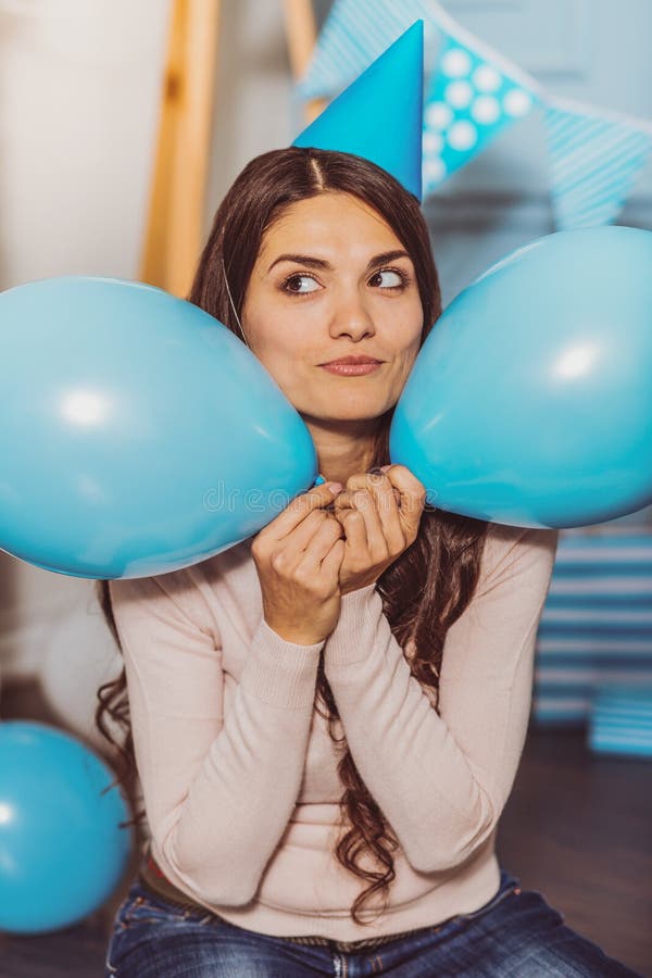 Szczęśliwa entuzjastyczna kobieta chuje między balonami obrazy stock Szczęśliwa entuzjastyczna kobieta chuje między balonami obrazy stock