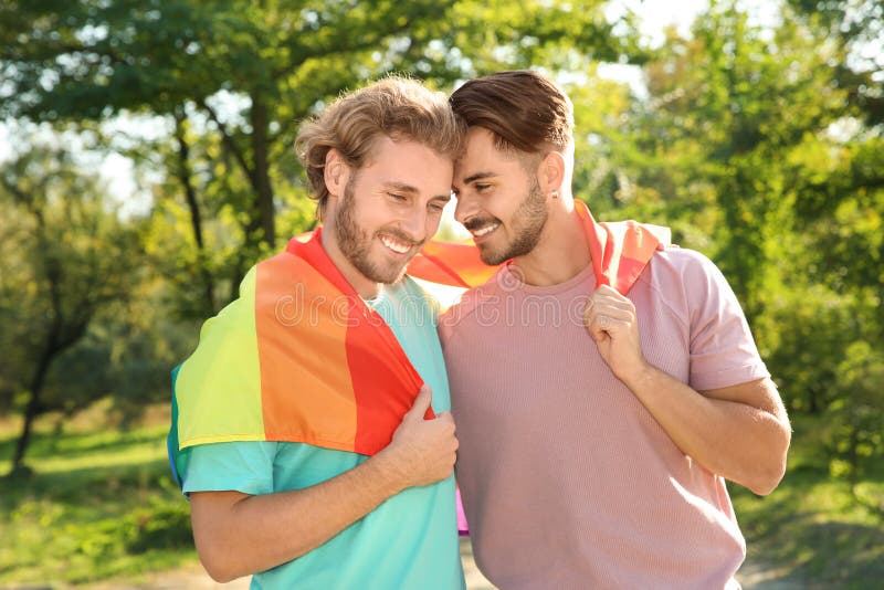 Szczęśliwa homoseksualna para z tęczy flagą obraz royalty free Szczęśliwa homoseksualna para z tęczy flagą obraz royalty free