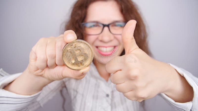 Szczęśliwa kobieta trzyma Złotego Bitcoin