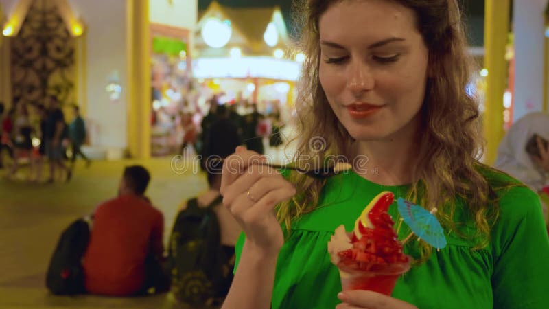 Szczęśliwa kobieta turystka z przyjemnością jedząc popsicles lody arabskie targi zdjęcie wideo