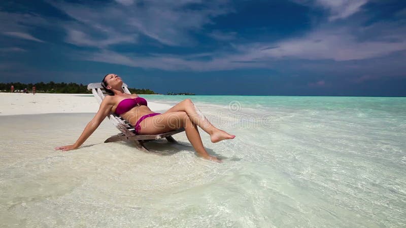 Szczęśliwa kobieta w krześle na dennej plaży w słonecznym dniu zdjęcie wideo