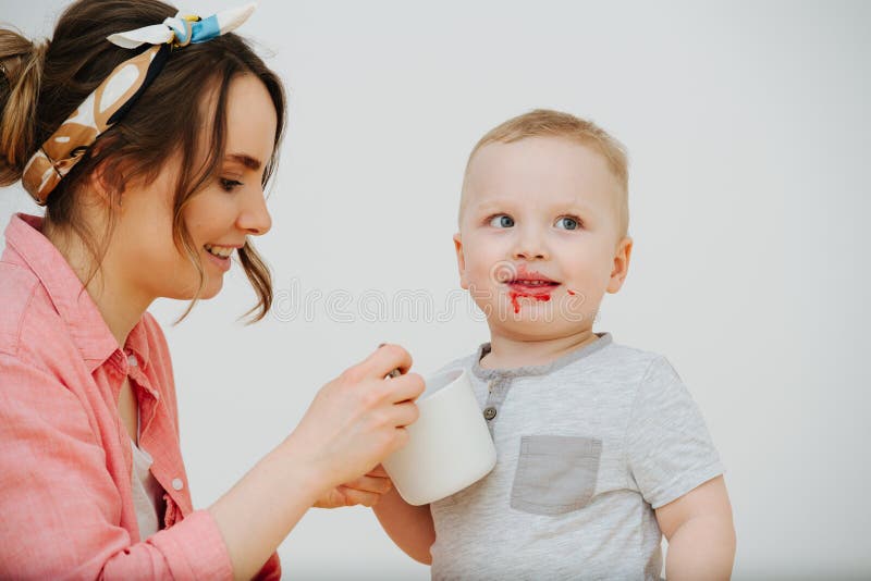 Szczęśliwa matka jest łyżkowym karmieniem jej berbecia syn z dżemem obrazy royalty free Szczęśliwa matka jest łyżkowym karmieniem jej berbecia syn z dżemem obrazy royalty free