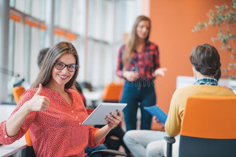 Happy young business women with her staff, people group in background at modern bright office indoors. Happy young business women with her staff, people group in background at modern bright office indoors.