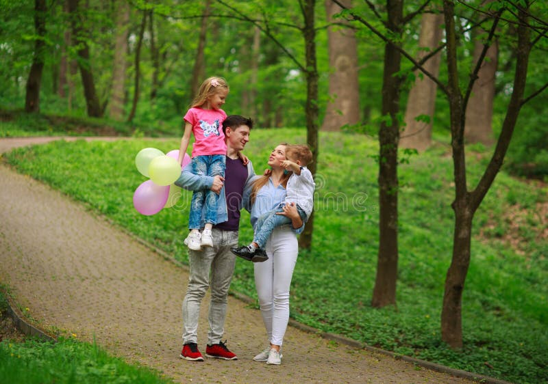 Szczęśliwa młoda rodzina z ich dwa dziećmi chodzi w lato lasu parku, rodzicielstwo wakacje z dzieciakami fotografia stock Szczęśliwa młoda rodzina z ich dwa dziećmi chodzi w lato lasu parku, rodzicielstwo wakacje z dzieciakami fotografia stock