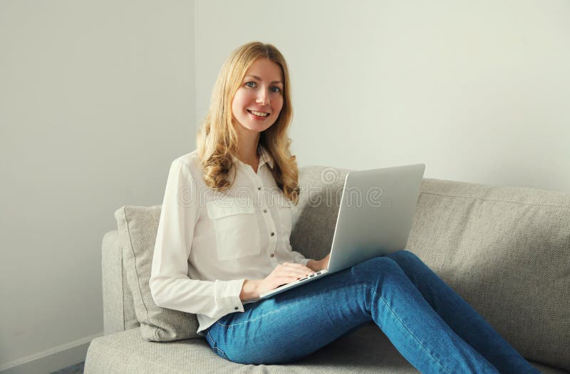 Szczęśliwa nowoczesna kobieta pracująca z dziewczyną freelancer siedzącą na kanapie w salonie obrazy royalty free