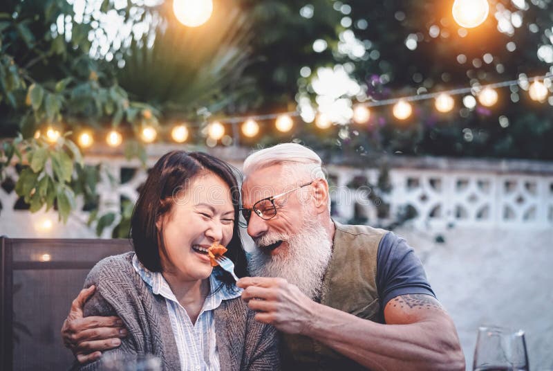 Szczęśliwa para w starszym wieku bawiąca się na przyjęciu w domu obiadowym