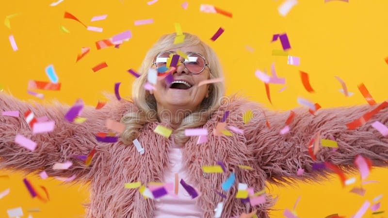 Szczęśliwa przechodzić na emeryturę kobieta rzuca w górę kolorowego confetti zwolnionego tempa, mieć zabawy przyjęcia