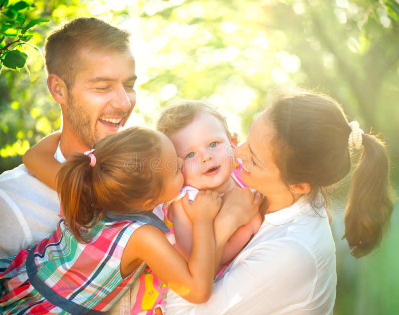 Szczęśliwa radosna młoda rodzina ma zabawę outdoors