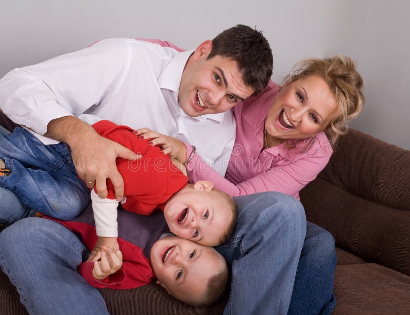 Young couple palying with their children at home, family concept. Young couple palying with their children at home, family concept