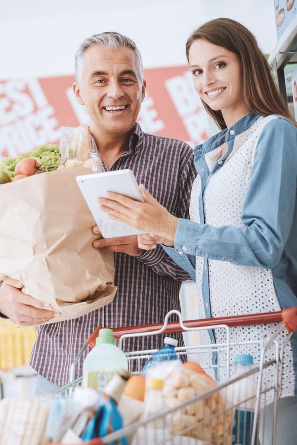 Szczęśliwa rodzina przy supermarketem fotografia stock Szczęśliwa rodzina przy supermarketem fotografia stock