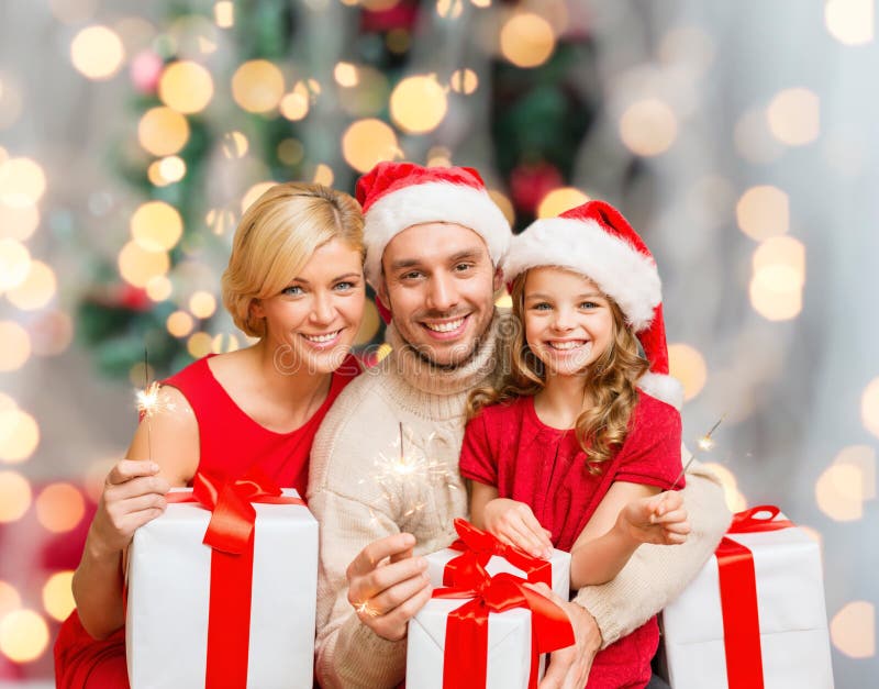 Szczęśliwa rodzina w Santa pomagiera kapeluszach z prezentów pudełkami zdjęcie stock Szczęśliwa rodzina w Santa pomagiera kapeluszach z prezentów pudełkami zdjęcie stock