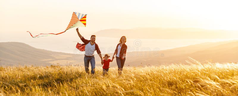 Happy family father, mother and child daughter launch a kite on nature at sunset. Happy family father, mother and child daughter launch a kite on nature at sunset