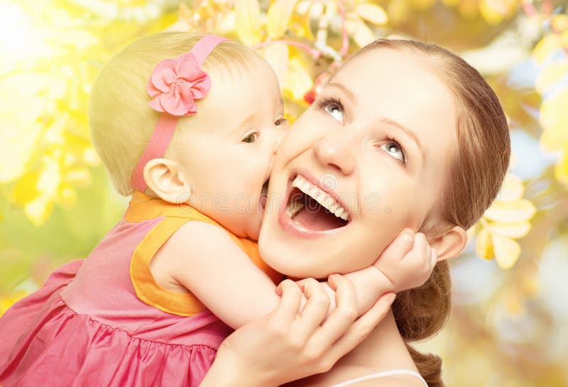 Szczęśliwa rozochocona rodzina. Matki i dziecka całowanie w naturze plenerowej