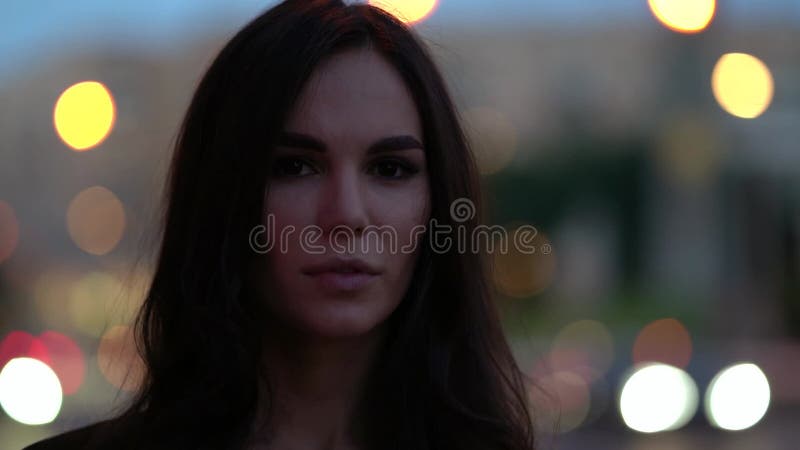 Szczęśliwa seksualna brunetka kobieta w wielkim mieście po zachodzie słońca światła w tle zbliżenie zdjęcie wideo