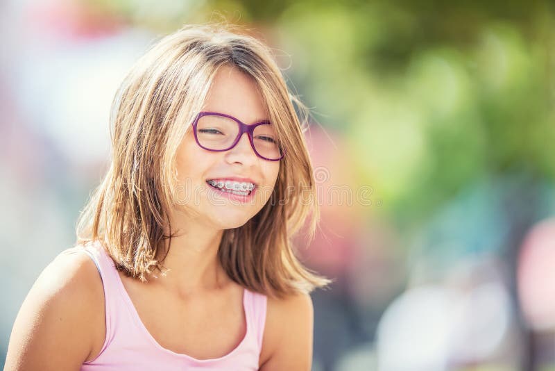 Szczęśliwa uśmiechnięta dziewczyna z stomatologicznymi brasami i szkłami Młoda śliczna caucasian blond dziewczyna jest ubranym zę obraz stock
