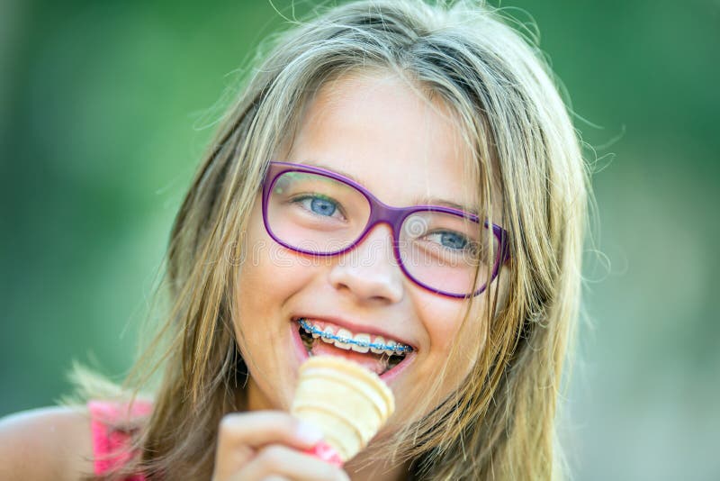 Szczęśliwa uśmiechnięta dziewczyna z stomatologicznymi brasami i szkłami Młoda śliczna caucasian blond dziewczyna jest ubranym zę zdjęcie royalty free