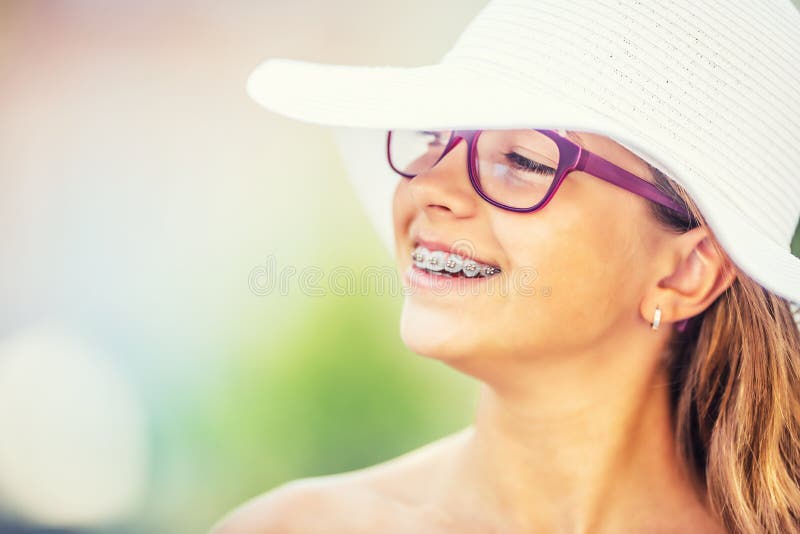 Szczęśliwa uśmiechnięta dziewczyna z stomatologicznymi brasami i szkłami Młoda śliczna caucasian blond dziewczyna jest ubranym zę obrazy stock