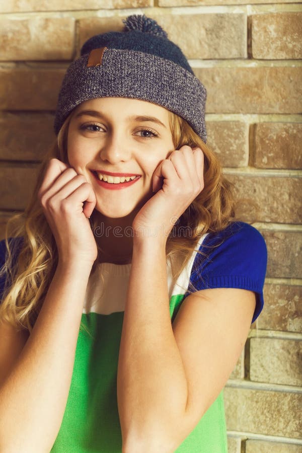 Szczęśliwa ładna dziewczyna ono uśmiecha się w popielatym beanie kapeluszu zdjęcia royalty free Szczęśliwa ładna dziewczyna ono uśmiecha się w popielatym beanie kapeluszu zdjęcia royalty free