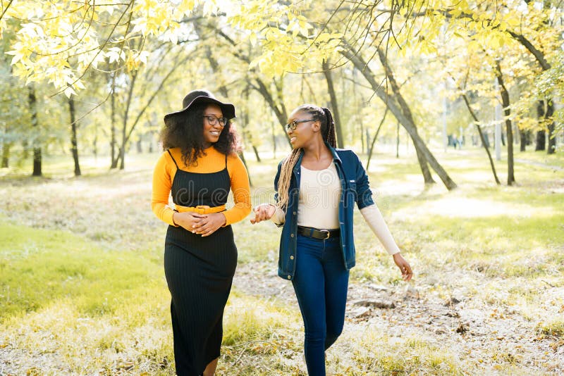 Happy african women friends walking outdoors in the park . Happy african women friends walking outdoors in the park .