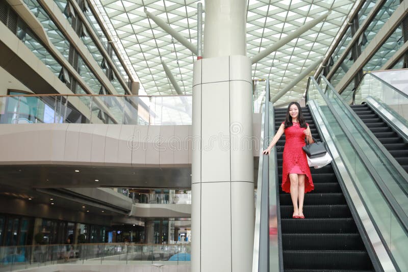 Szczęśliwe Azjatyckie Chińskie nowożytne modnej kobiety torby na zakupy w centrum handlowe sklepu odzieży okularów przeciwsłonecz zdjęcie stock Szczęśliwe Azjatyckie Chińskie nowożytne modnej kobiety torby na zakupy w centrum handlowe sklepu odzieży okularów przeciwsłonecz zdjęcie stock