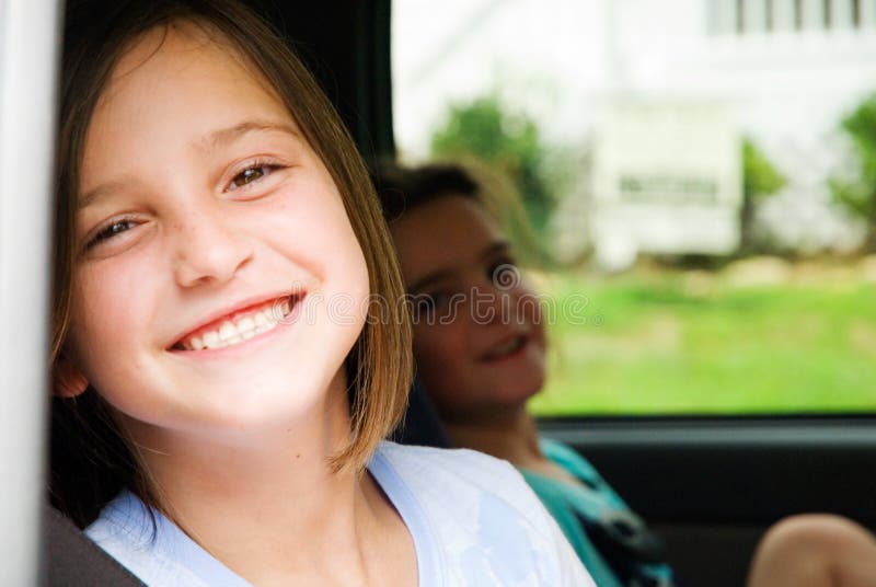 Two smiling, happy, girls sitting in a car, with seat belts on. Two smiling, happy, girls sitting in a car, with seat belts on.