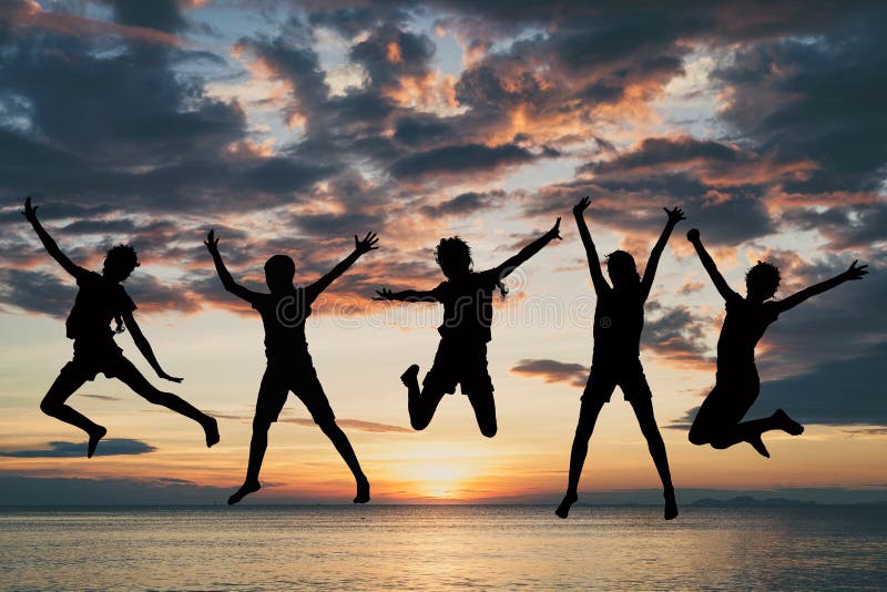 Happy girls jumping on the beach at the sunset time. People having fun outdoors. Concept of success of team. Happy girls jumping on the beach at the sunset time. People having fun outdoors. Concept of success of team.