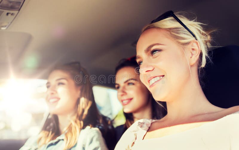 Szczęśliwe nastoletnie dziewczyny lub młode kobiety jedzie w samochodzie