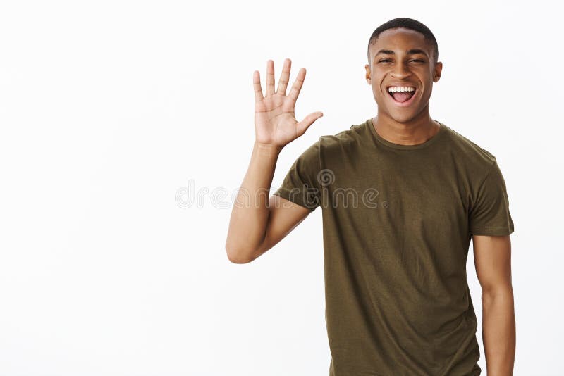 Szczęśliwego atrakcyjnego amerykanin afrykańskiego pochodzenia mężczyzny dźwigania charyzmatyczna palma dawać wysokości lub macha