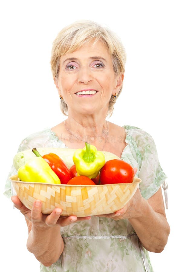 Happy blond senior woman holding a bowl with fresh vegetables isolated on white background,check also my collection. Happy blond senior woman holding a bowl with fresh vegetables isolated on white background,check also my collection