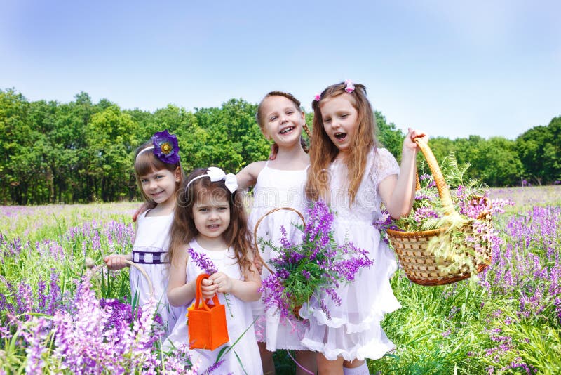 Four happy girls holding baskets with fresh flowers. Four happy girls holding baskets with fresh flowers