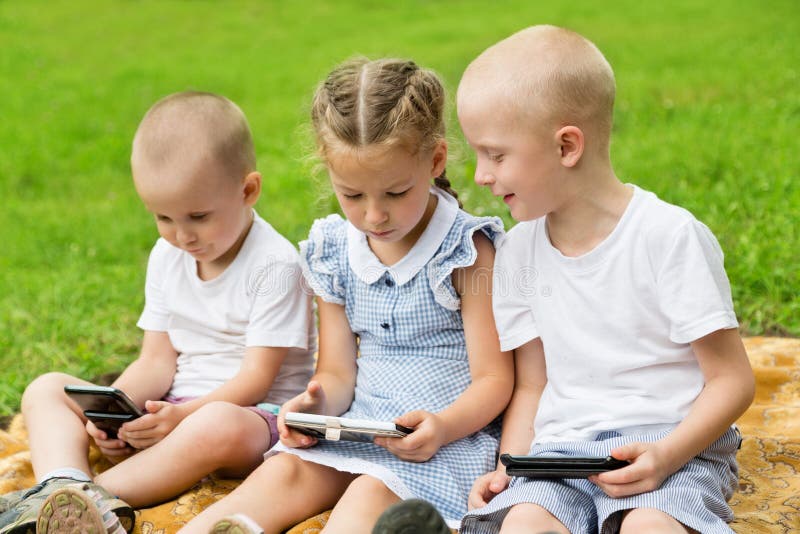 Szczęśliwi bracia i siostra używa smartphones zdjęcie royalty free