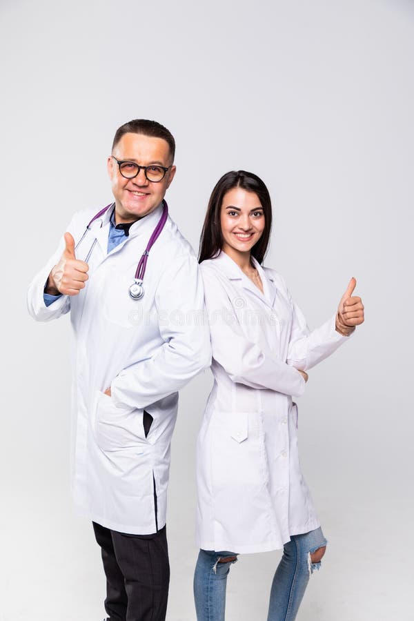Szczęśliwi medycy. portret dwóch lekarzy w białych płaszczach i okularach pokazujących kciuk na białym tle zdjęcia stock