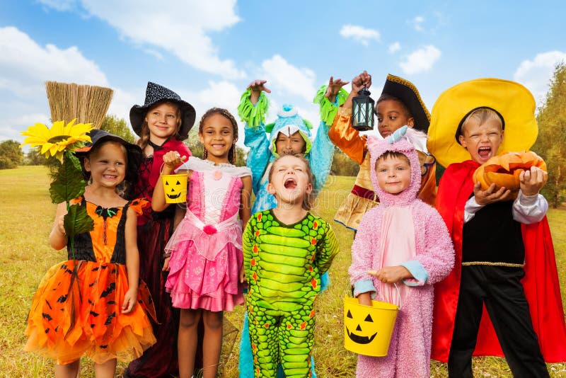 Szczęśliwi z podnieceniem dzieciaki w Halloweenowych kostiumach