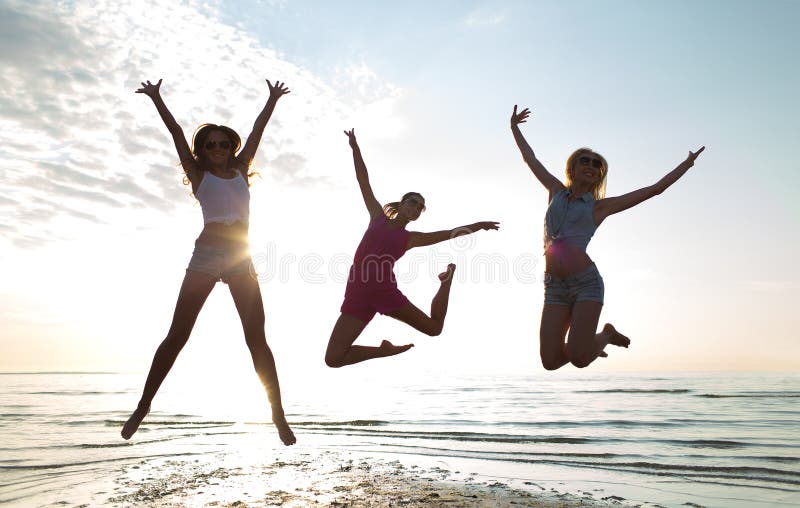 Friendship, summer vacation, freedom, happiness and people concept - group of happy female friends dancing and jumping on beach. Friendship, summer vacation, freedom, happiness and people concept - group of happy female friends dancing and jumping on beach