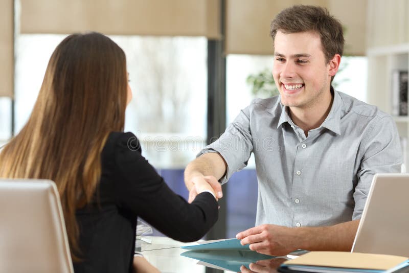 Happy businesspeople handshaking after negotiation at office. Happy businesspeople handshaking after negotiation at office