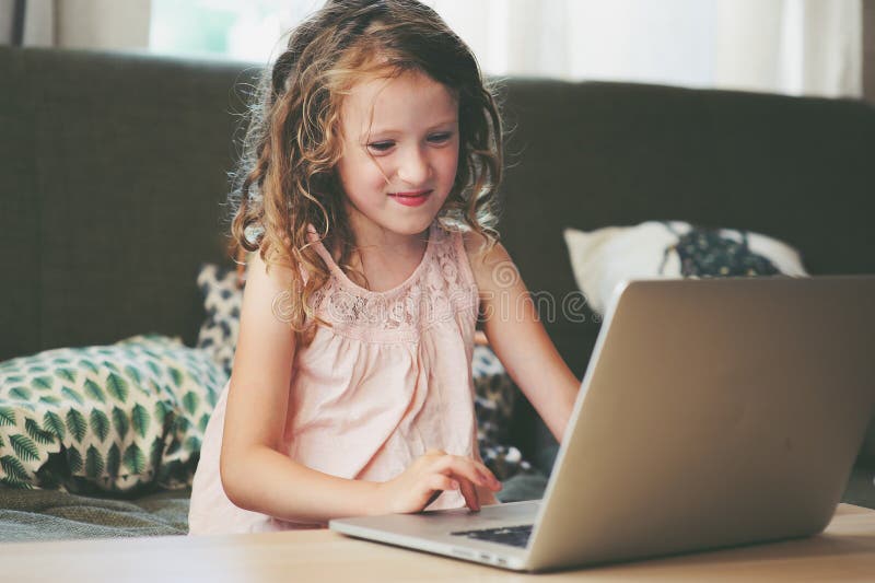 Szczęśliwy dziecko używa laptop w domu Szkolny dziewczyna uczenie z komputerem i internetem obrazy stock Szczęśliwy dziecko używa laptop w domu Szkolny dziewczyna uczenie z komputerem i internetem obrazy stock