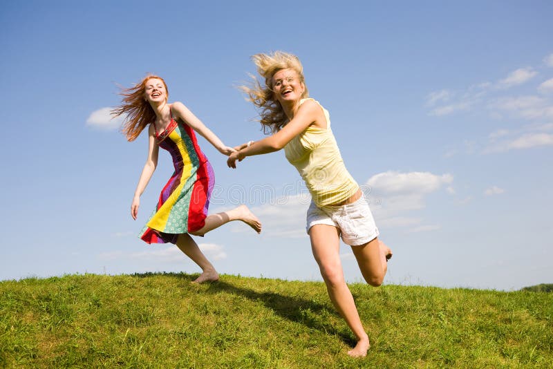 Two happy girls jumping. Blue sky. Two happy girls jumping. Blue sky.