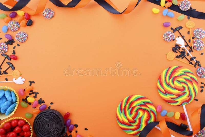 Halloween or Childrens Birthday candy favors on a bright orange background with decorated borders and copy space. Halloween or Childrens Birthday candy favors on a bright orange background with decorated borders and copy space.