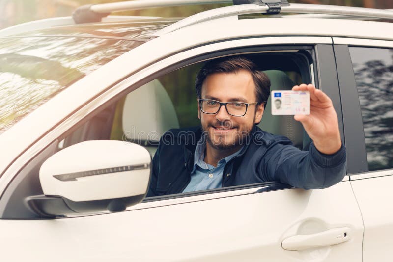 Szczęśliwy mężczyzna pokazuje jego nowego prawo jazdy