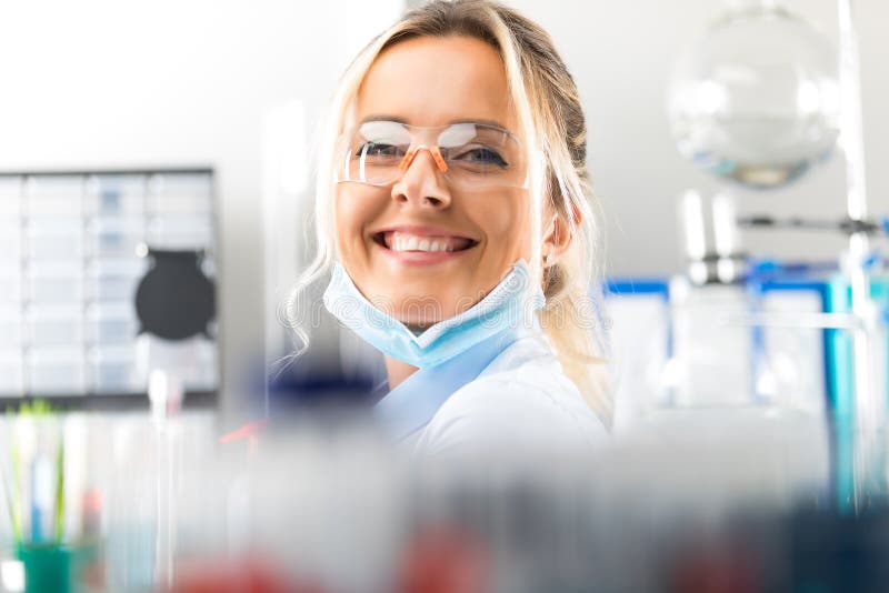 Szczęśliwy młody atrakcyjny uśmiechnięty kobieta naukowiec w laboratorium zdjęcia stock