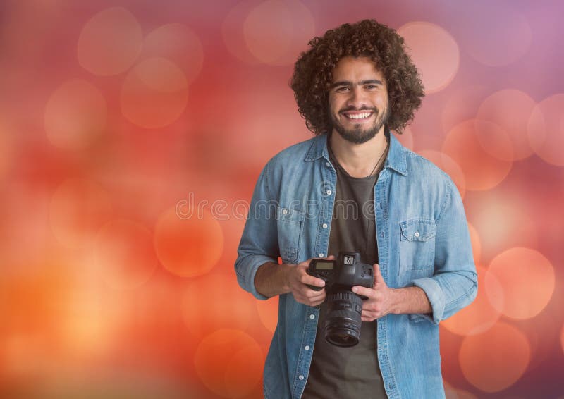 szczęśliwy młody fotograf z kamerą na rękach Bokeh czerwony tło fotografia stock szczęśliwy młody fotograf z kamerą na rękach Bokeh czerwony tło fotografia stock