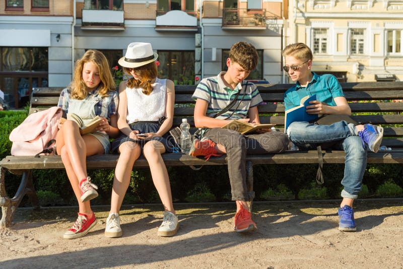 Szczęśliwy 4 nastoletniego przyjaciela lub szkoła średnia ucznie czyta telefon mają zabawę, opowiadający, książka Przyjaźń i ludz zdjęcia stock Szczęśliwy 4 nastoletniego przyjaciela lub szkoła średnia ucznie czyta telefon mają zabawę, opowiadający, książka Przyjaźń i ludz zdjęcia stock