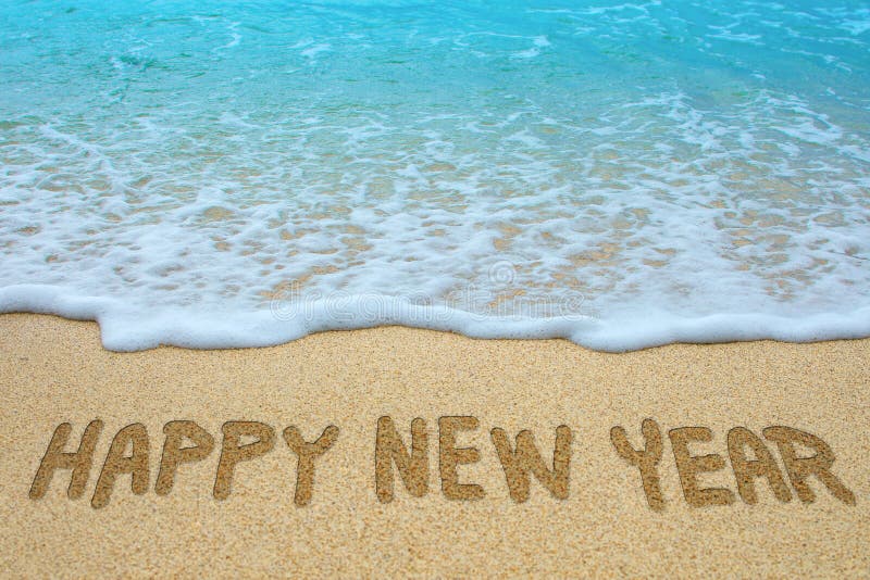 Szczęśliwy nowy rok pisać na piaskowatej plaży
