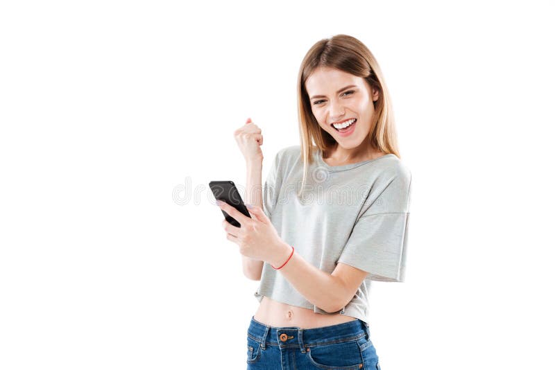 Szczęśliwy radosny dziewczyny mienia telefon komórkowy i odświętność wygrana zdjęcia royalty free Szczęśliwy radosny dziewczyny mienia telefon komórkowy i odświętność wygrana zdjęcia royalty free