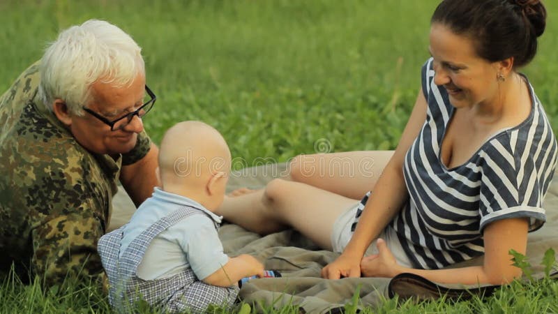 Szczęśliwy rodzinny bawić się z berbeć chłopiec w lato parku z piękną trawą troszkę Matka, dziecko, dziad