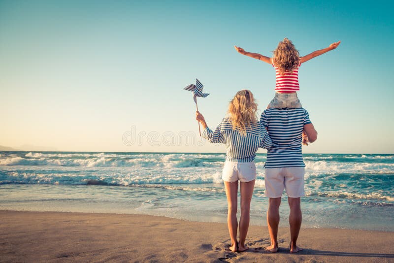 Happy family on the beach. People having fun on summer vacation. Father, mother and child against blue sea and sky background. Holiday travel concept. Happy family on the beach. People having fun on summer vacation. Father, mother and child against blue sea and sky background. Holiday travel concept