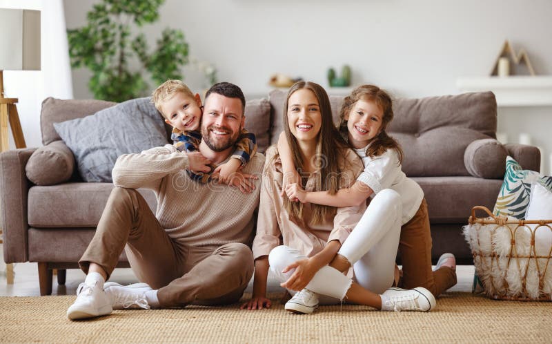 Happy family mother father and children at home on the couch. Happy family mother father and children at home on the couch