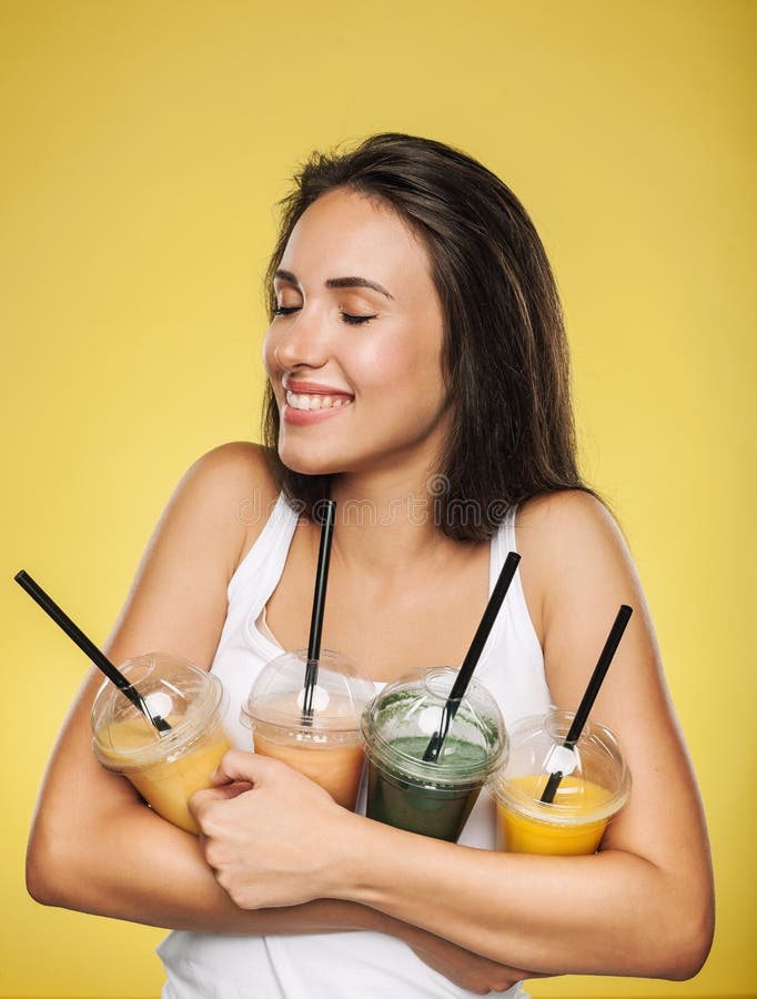 Szczęśliwy uśmiechnięty kobiety mienia smoothie obraz stock Szczęśliwy uśmiechnięty kobiety mienia smoothie obraz stock